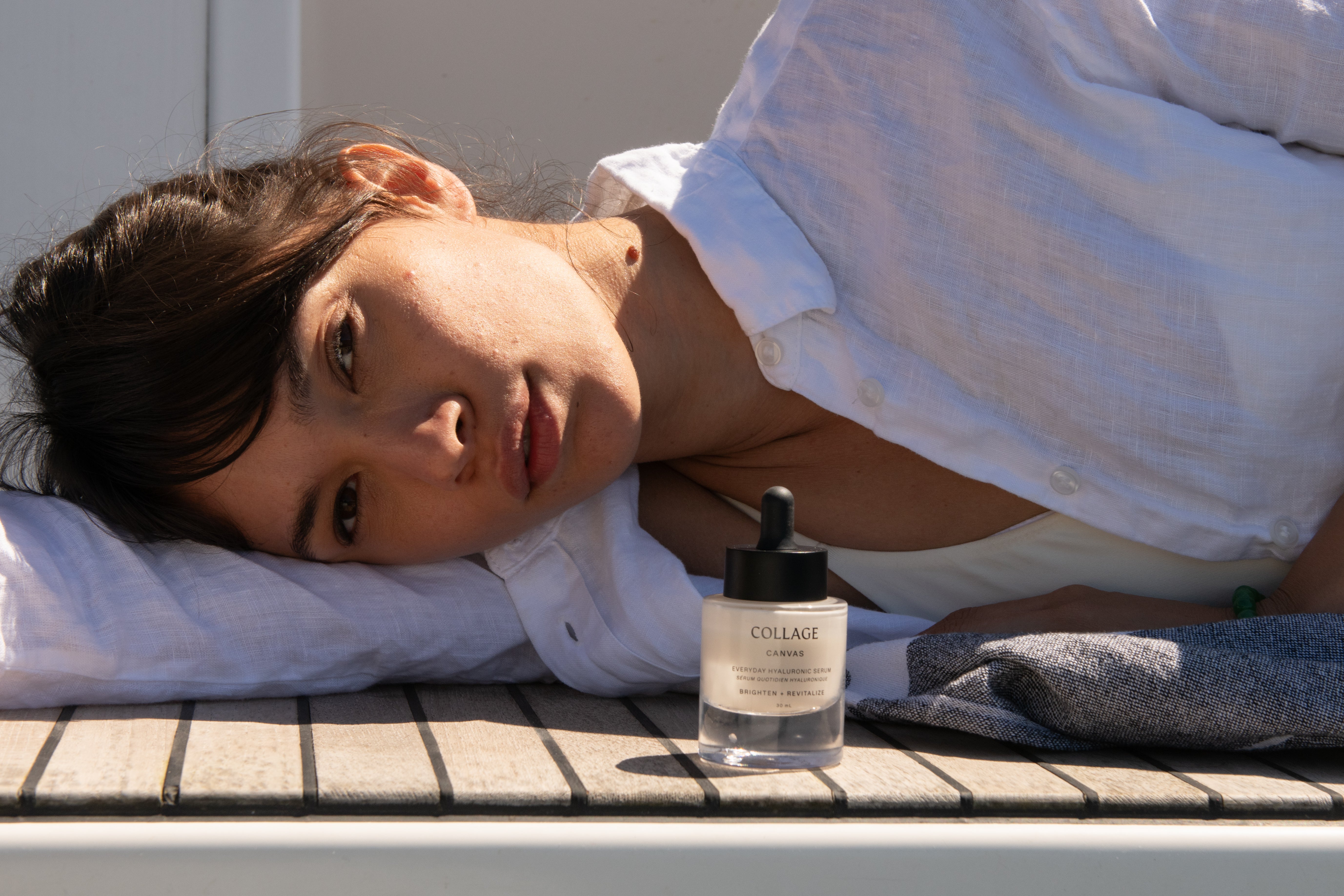 Woman laying on a pool deck with Collage Skincare